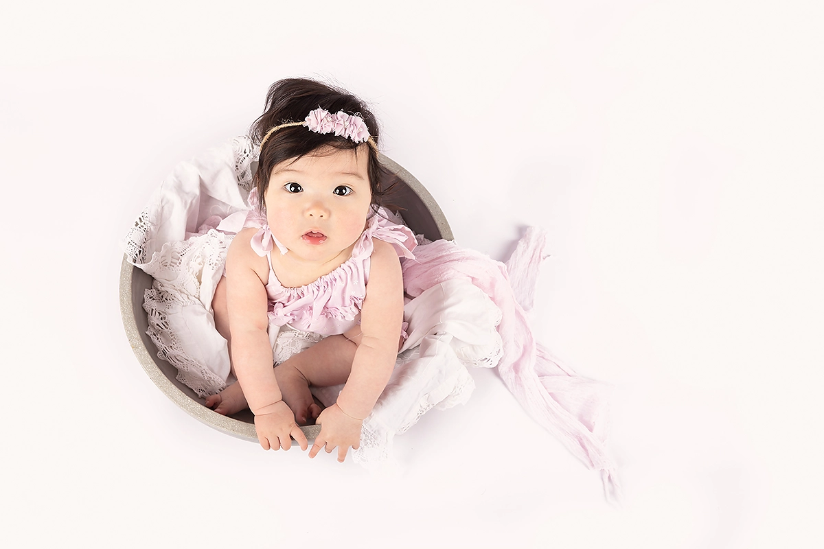 Baby met grote glimlach tijdens sittershoot door Margje Fotografie in Maassluis