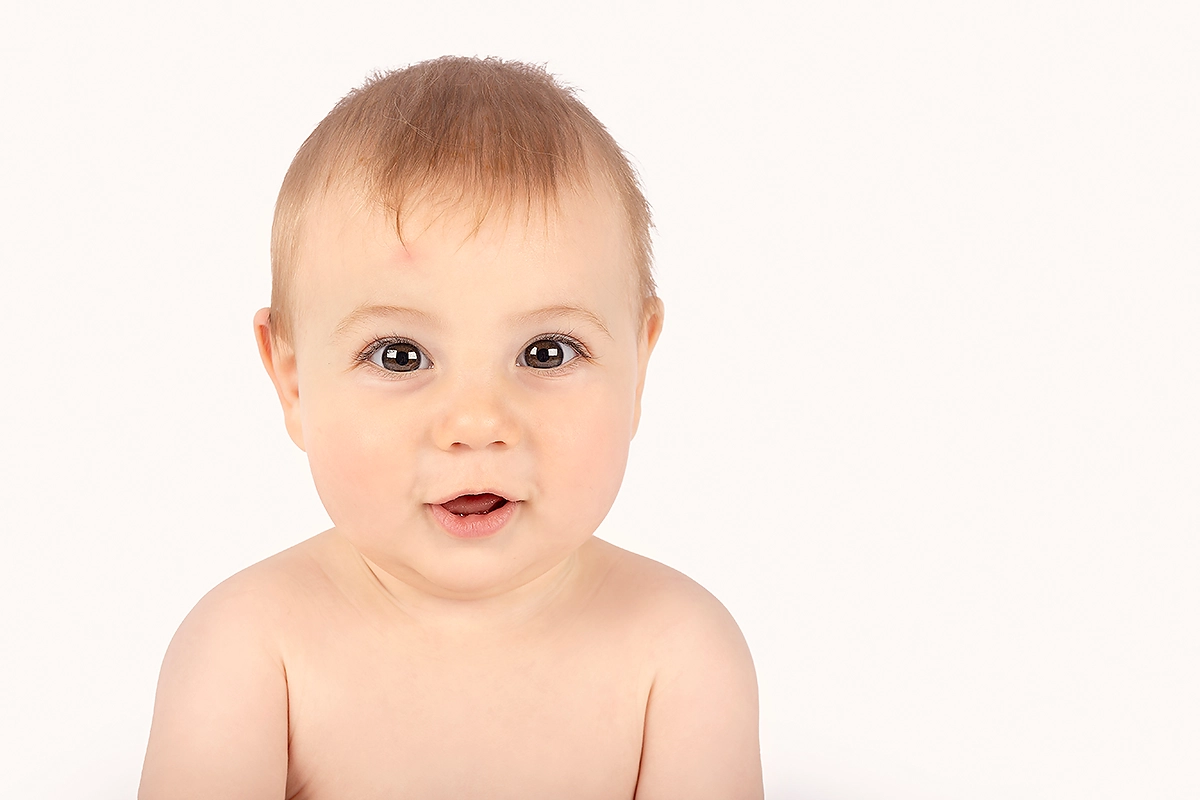 Baby met grote glimlach tijdens sittershoot door Margje Fotografie